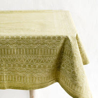 2: A green tablecloth with a white geometric print spread out over a table.