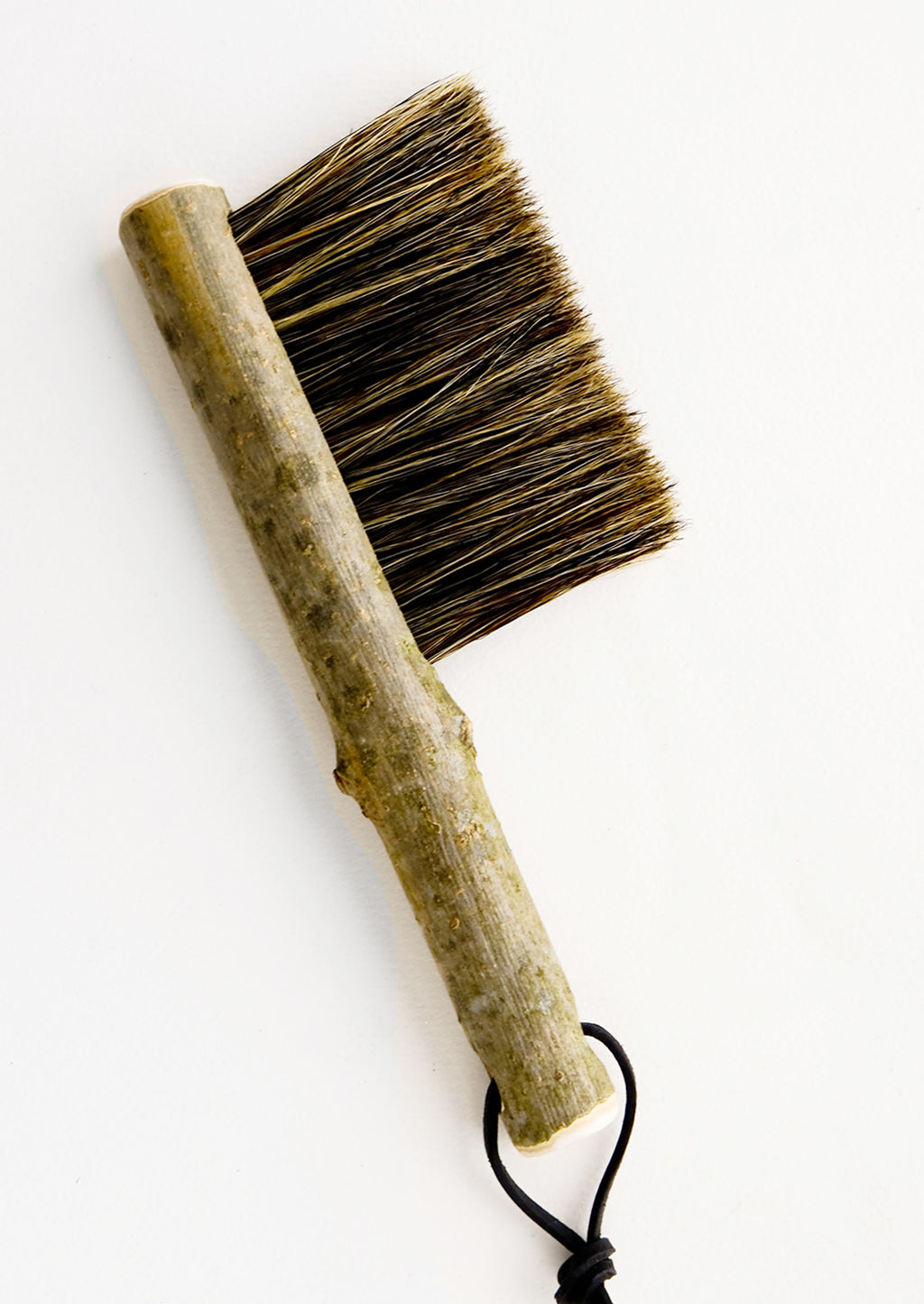 1: Bristle brush with natural bark handle and leather tie at end