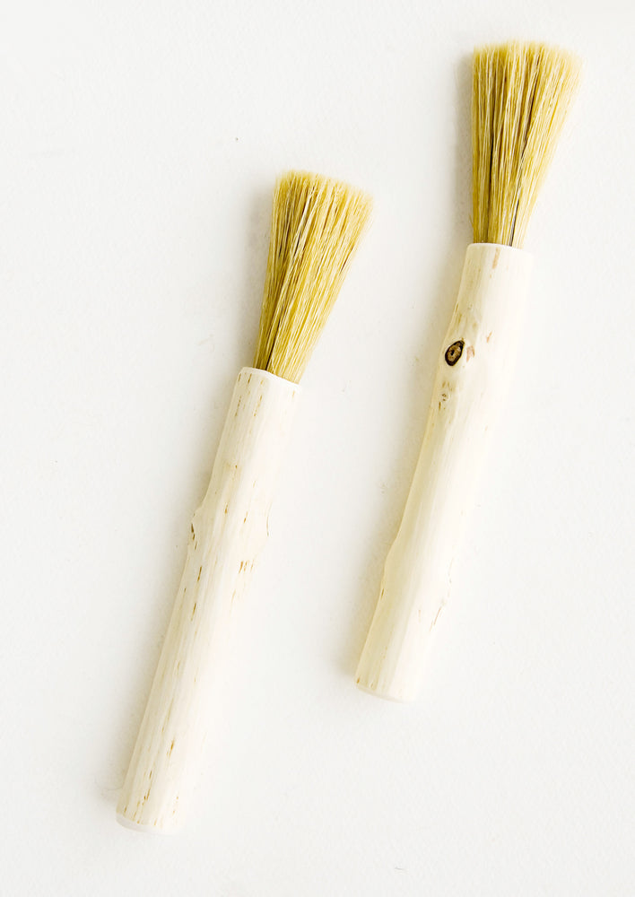 Hard-carved wooden pastry brush in long and skinny shape with bristle end