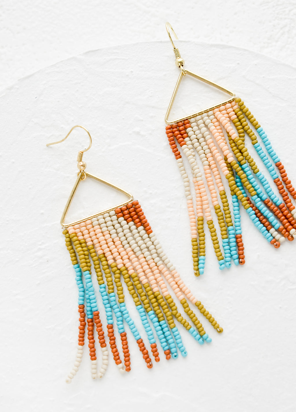 Earthy Multi: A pair of statement earrings with triangle metal top and fringe beads below.
