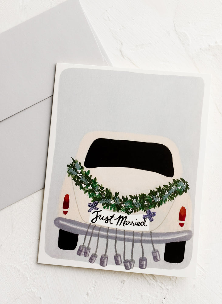1: A greeting card with illustration of a car dressed up with "just married" bells.