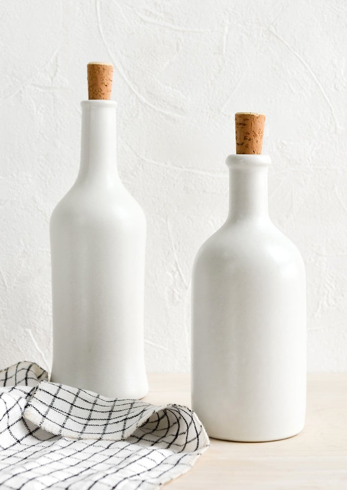 Matte white ceramic bottles in short and tall heights, with cork stoppers.