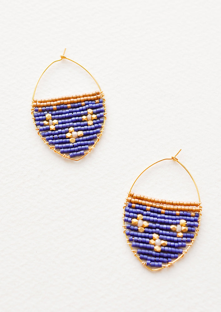 Delicate gold drop earrings with a field of blue glass beads featuring three gold equal-armed cross designs.
