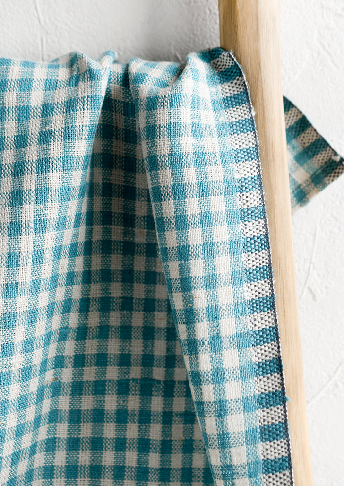 A woven gingham linen tea towel in blue turquoise color.
