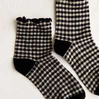 Black: A pair of black gingham patterned socks with ankle ruffle.
