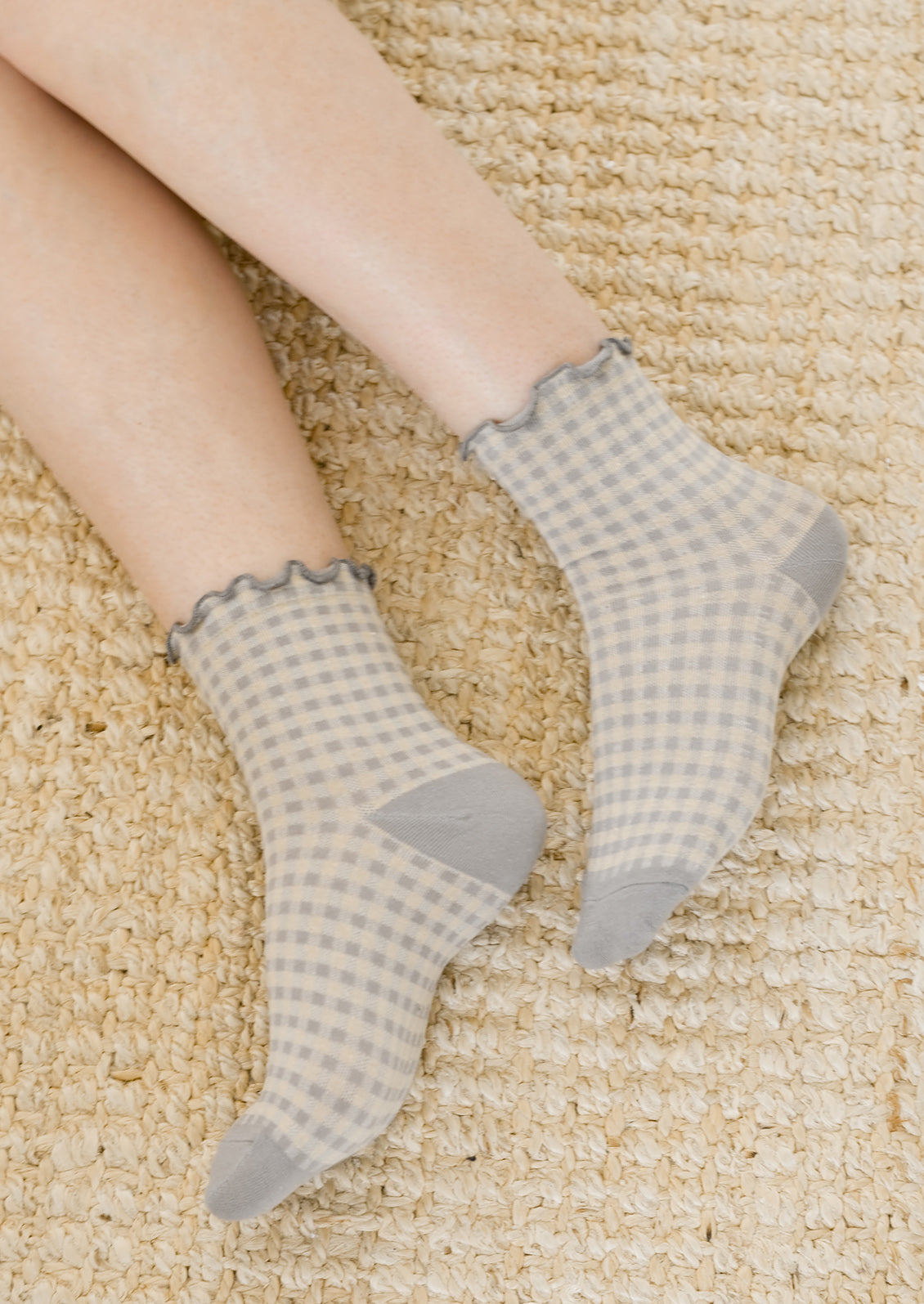 A woman's ankles wearing grey gingham socks.