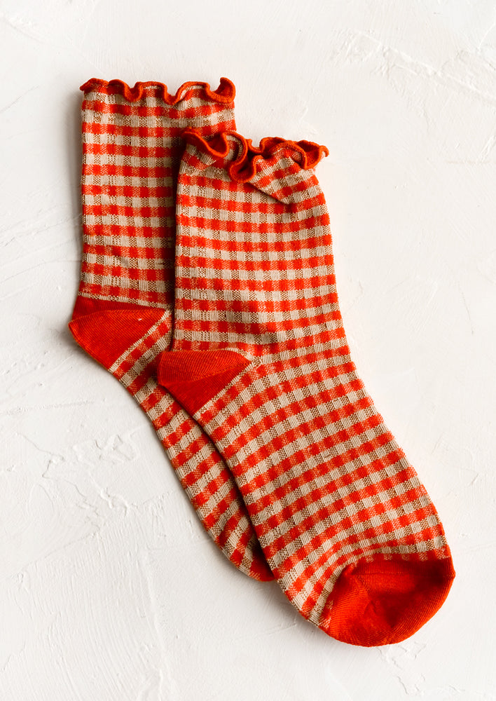 A pair of red gingham patterned socks with ankle ruffle.