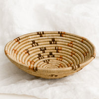 2: A tan woven bowl with brown and terracotta accents.