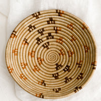 1: A tan woven bowl with brown and terracotta accents.