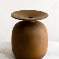 1: A brown distressed ceramic vase with saucer-like top.