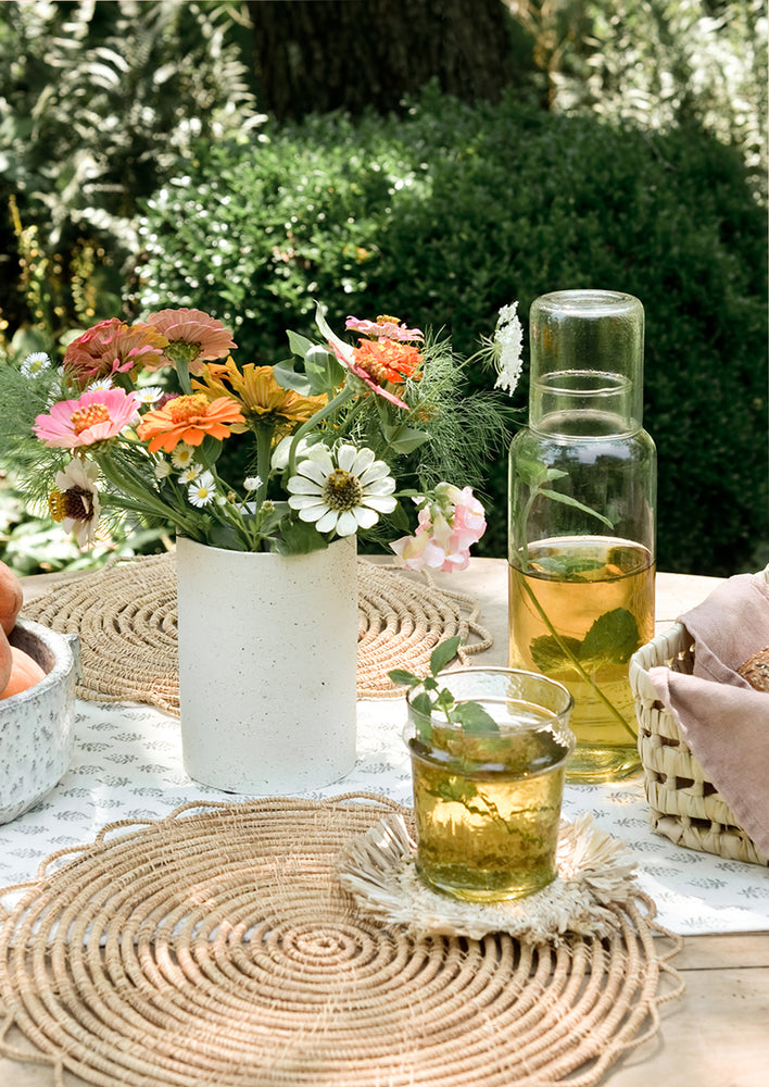 A table setting with mint tea in glass decanter.
