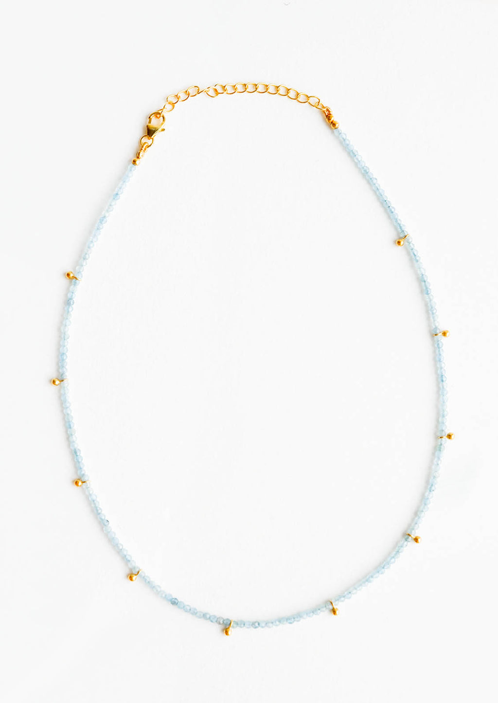 Aqua Chalcedony: A necklace of clear blue stones with evenly spaced gold beads and a golden chain clasp.