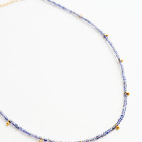 Iolite: A necklace of deep blue stones with evenly spaced gold beads and a golden chain clasp.