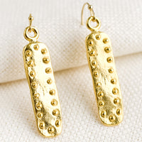 Short: A pair of short bar shaped earrings with raised dot border.