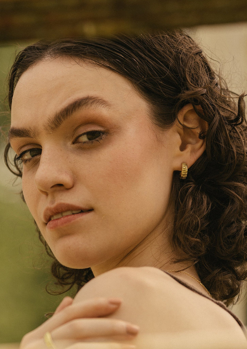 2: A woman wearing brass earrings.