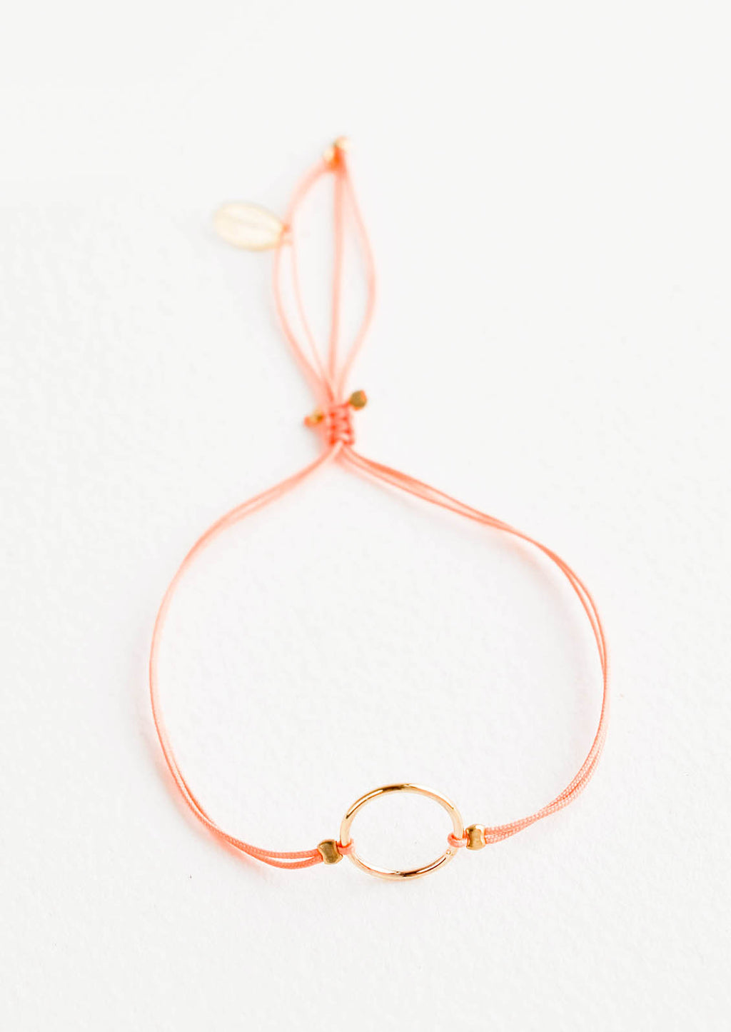 Peach: Bracelet with yellow gold circle charm centered on an adjustable peach string.
