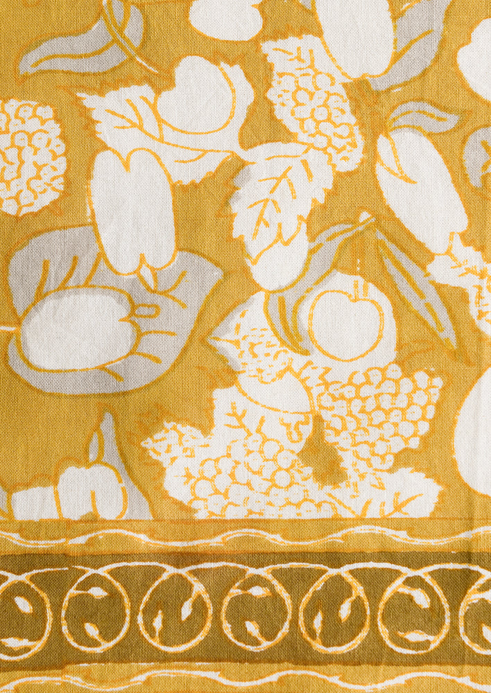 2: A pair of mustard/gold napkins with fruit print.