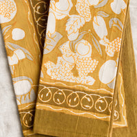 1: A pair of mustard/gold napkins with fruit print.