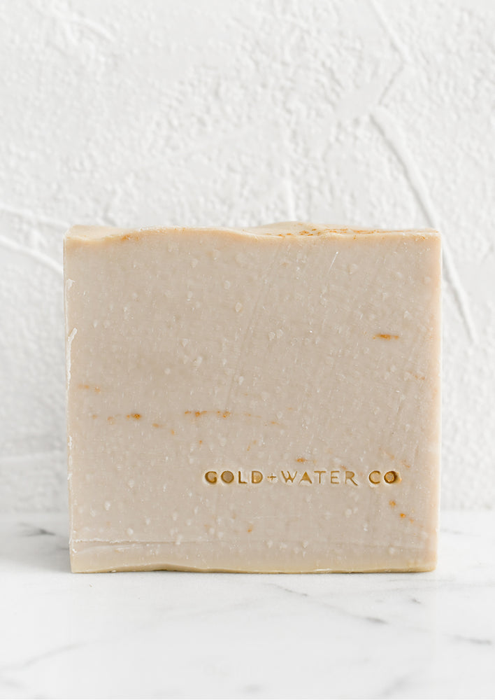 A blush bar of soap with brand stamp at corner.