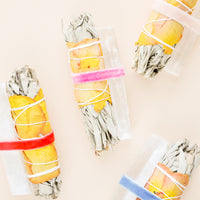 2: Four sage and crystal bundles each held together by velvet ribbons.
