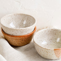3: A stack of three small speckled ceramic bowls.