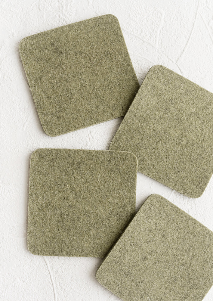 A set of four square merino wool coasters in sage green.