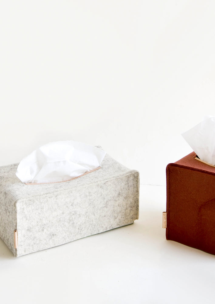 Tissue box covers in cube and rectangle shapes made from felted wool with natural leather accents