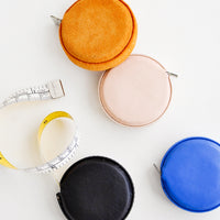 1: Product shot featuring multiple styles of leather covered tape measures.
