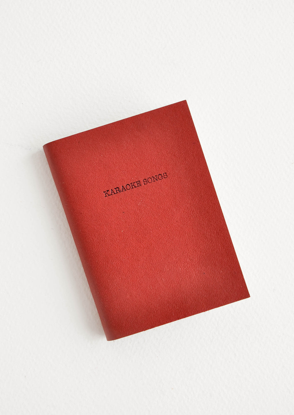 Karaoke Songs / Rust: Mini red notebook featuring text "Karaoke Songs".