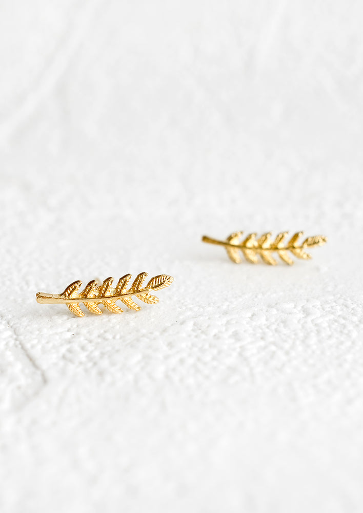 A pair of climber style stud earrings in gold leaf shape.