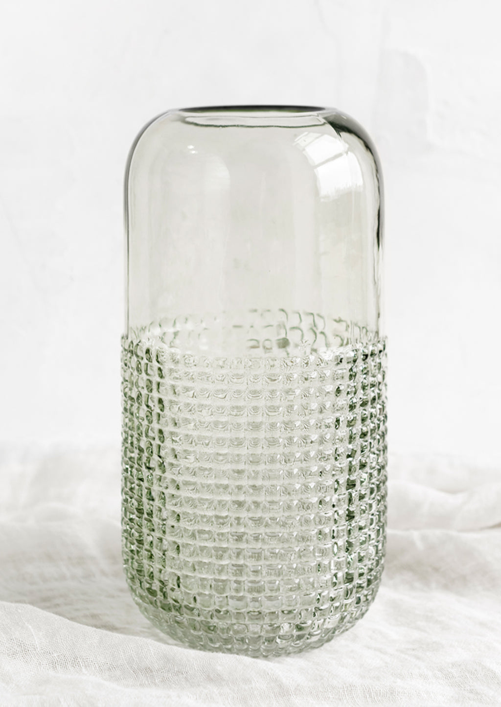 Tall: A glass vase with pyramid grid texture on lower half.