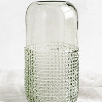 Tall: A glass vase with pyramid grid texture on lower half.