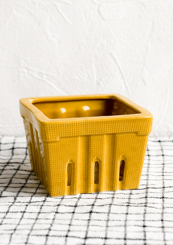 A ceramic berry basket in dijon yellow.