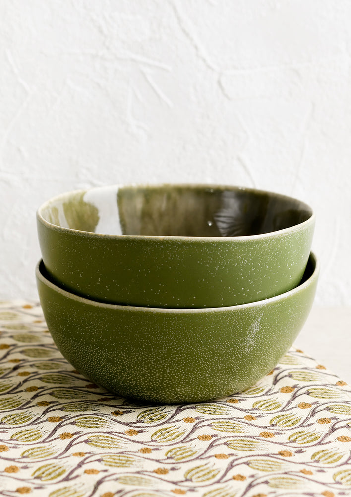 Two stacked olive green ceramic bowls.
