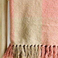 2: A cotton blank in peach and tan check pattern with fringe trim.