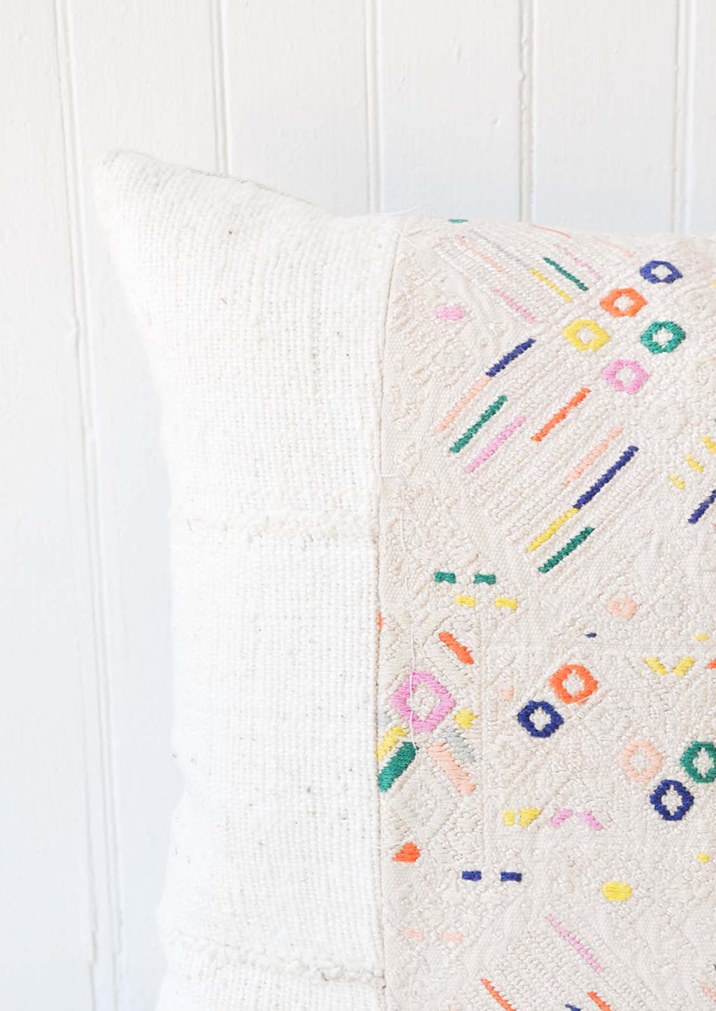 3: A white and multi-colored printed pillow.