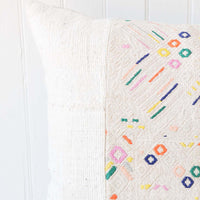 3: A white and multi-colored printed pillow.