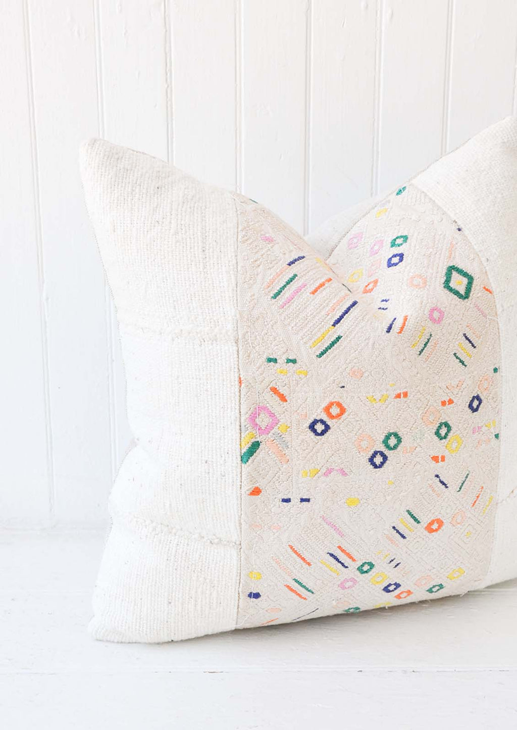 1: A white and multi-colored printed pillow.