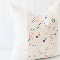 1: A white and multi-colored printed pillow.