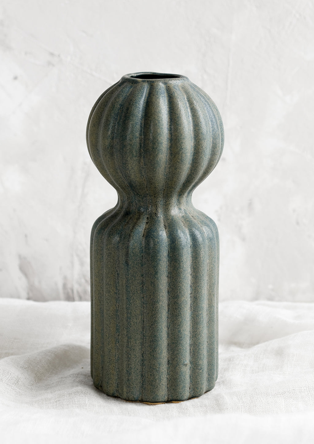 1: A curvy ceramic vase in teal glaze with ball-shaped top.