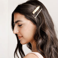 2: Two gold rectangular hair clips shown on model with brown hair