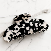 White / Black: A terrazzo hair claw in black with white spots.