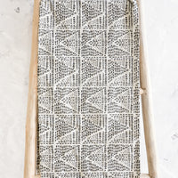 1: Table runner in natural cotton with black border and geometric print in black, displayed on a wooden ladder