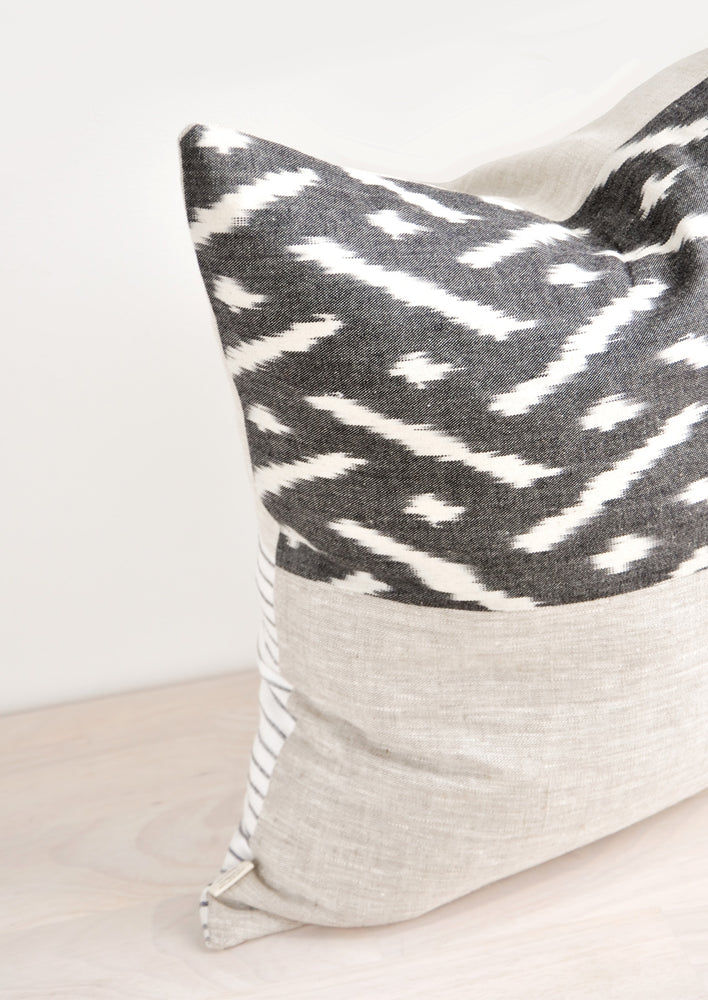 Square throw pillow in reversible design with contrasting black and white fabric on front and back