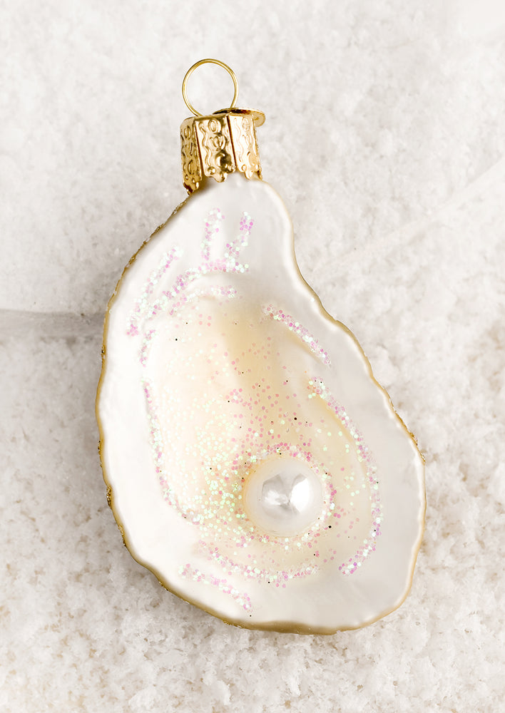 Holiday ornaments in the shape of a half oyster shell with pearl.