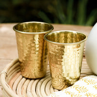 1: Two hammered brass tumblers on a tray.