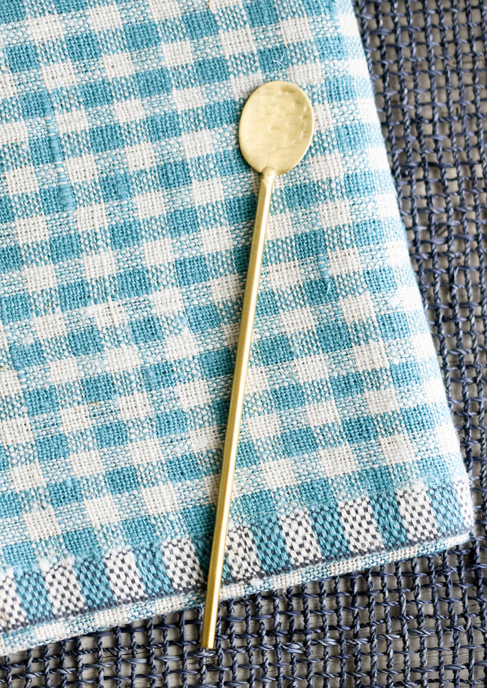 Cocktail Spoon: A long, skinny hammered gold spoon with slim, round handle.