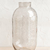 Smoke: A tall glass vase with hammered texture in pale grey.