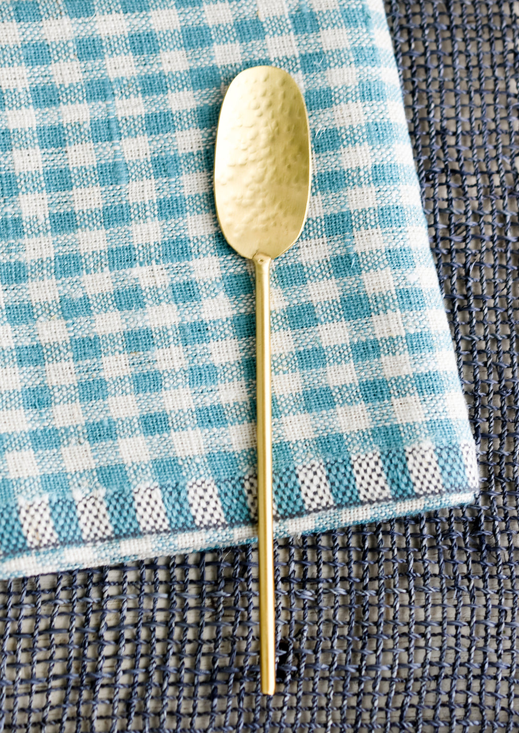 Tasting Spoon: A wide and long hammered gold spoon with slim, round handle.