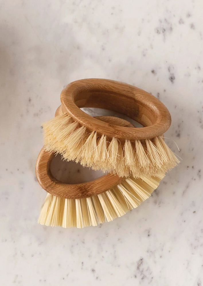 Oval-shaped handheld kitchen brushes on a marble countertop